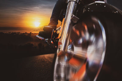 Close-up of bicycle on road against sky during sunset