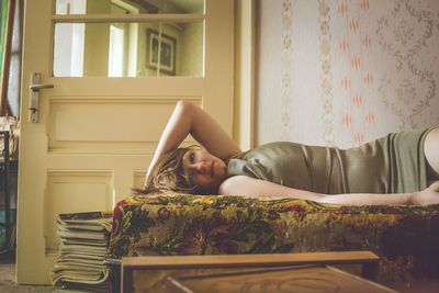 Portrait of woman lying on bed at home