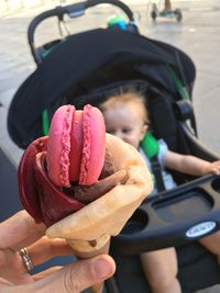 Close-up of cropped woman holding ice cream cone by toddler on street