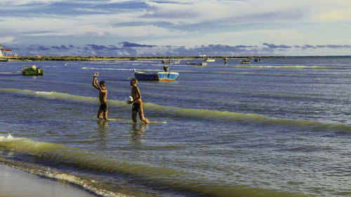 People standing on beach against sky