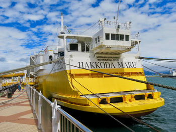 Ship moored on pier by sea against sky