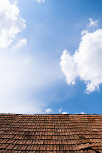 Low angle view of house roof against sky