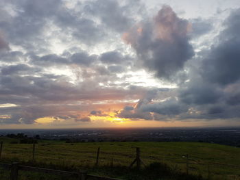 Scenic view of field against dramatic sky