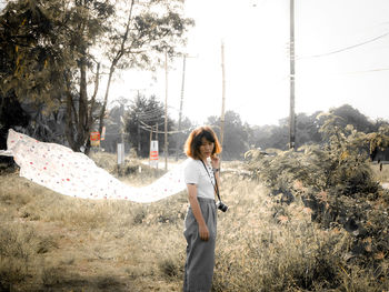 Side view of young woman standing on land