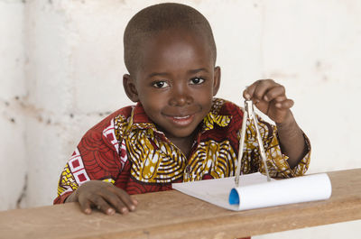 Portrait of cute boy holding table