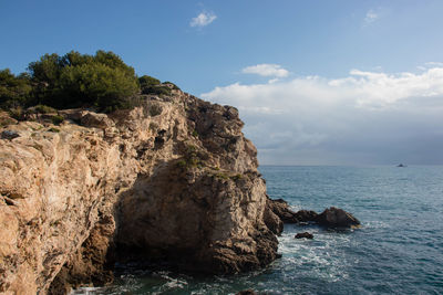 Rock formations by sea against sky