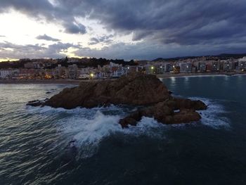 Scenic view of sea and houses against sky at sunset