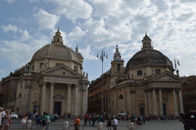 Group of people at town square against sky