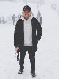 Portrait of young man standing in snow