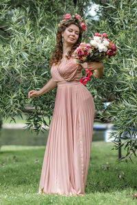 Portrait of smiling young woman standing against plants