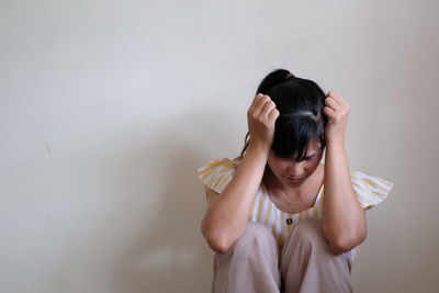 Midsection of woman with hands against wall