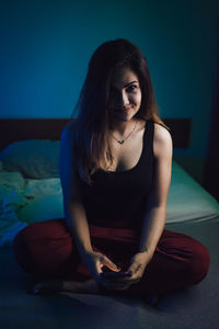 Portrait of woman using phone on bed at home