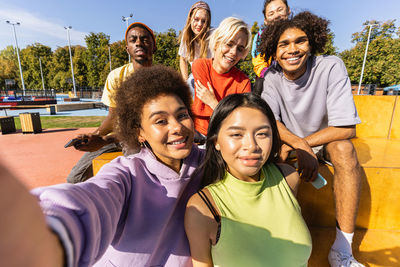 Portrait of happy friends sitting in park