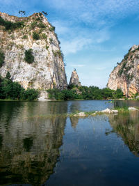 Rock formation by water against sky