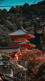 Tilt image of building by trees and mountains