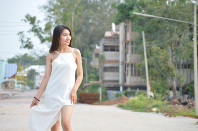 Full length of woman standing against trees