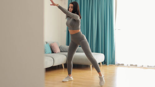 Full length of woman exercising on hardwood floor