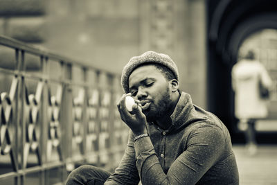 Man holding pebble sitting outdoors