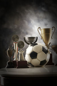 Close-up of trophies on table against black background