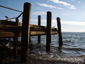 Wooden structure in sea against sky