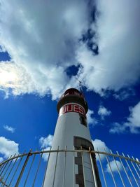 Low angle view of lighthouse by building against sky