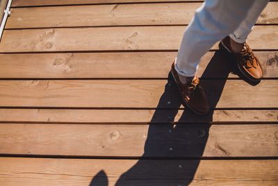 Low section of man standing on wood