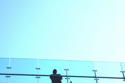 Low angle view of man against clear blue sky