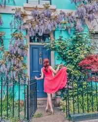 Full length of woman standing by building