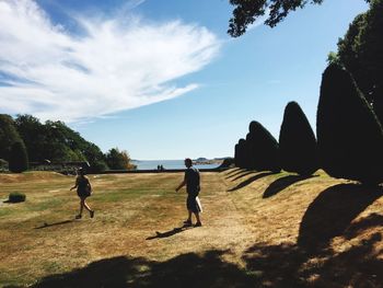 People on street amidst trees against sky