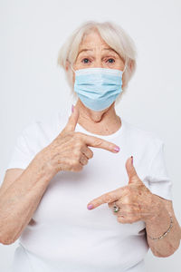 High angle view of woman holding dentures against white background