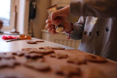 Midsection of woman preparing gingerbread cookies at table