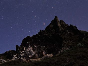 Low angle view of majestic mountain against sky at night