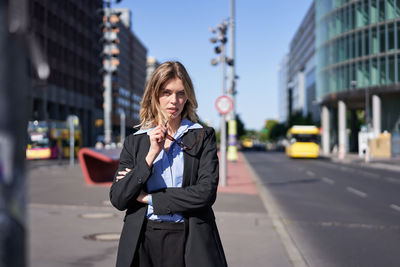 Young woman standing on street in city