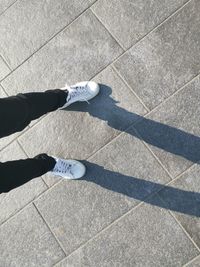 Low section of man standing on tiled floor