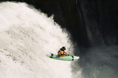 Whitewater kayaker descending waterfall