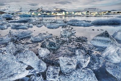 Frozen lake against sky during winter