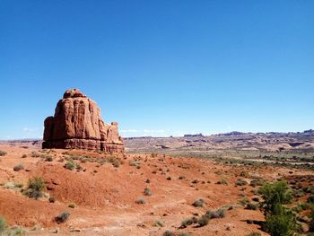 Rock formations in desert against clear blue sky