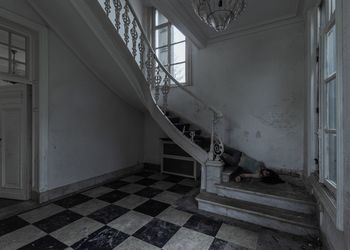 Unconscious woman lying on staircase in abandoned home