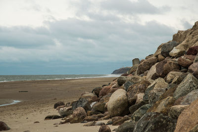 Rocks on beach against sky