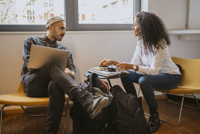 Male and female university students discussing while studying together