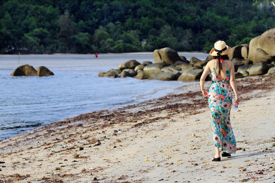 Woman standing on rock at beach