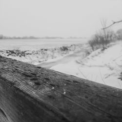 Close-up of snow on landscape against sky