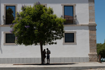 Man and woman walking by building