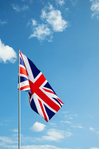 Low angle view of flag against blue sky