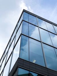 Low angle view of glass building against sky