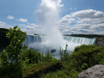 Scenic view of waterfall against sky