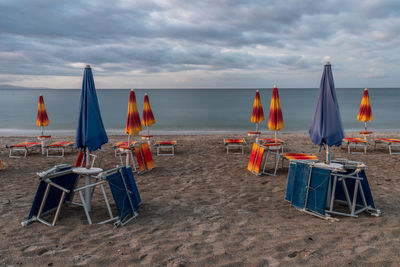 Chairs and umbrellas on the beach against sky