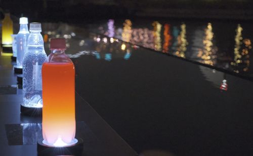 Close-up of lit candles on table at night