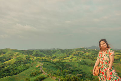 Woman standing on landscape against sky