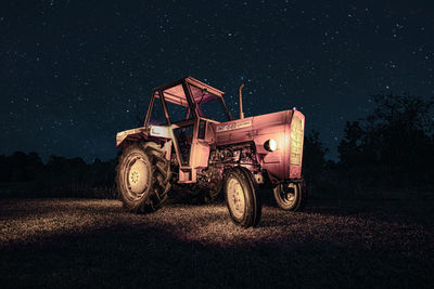Vintage car on field against sky at night